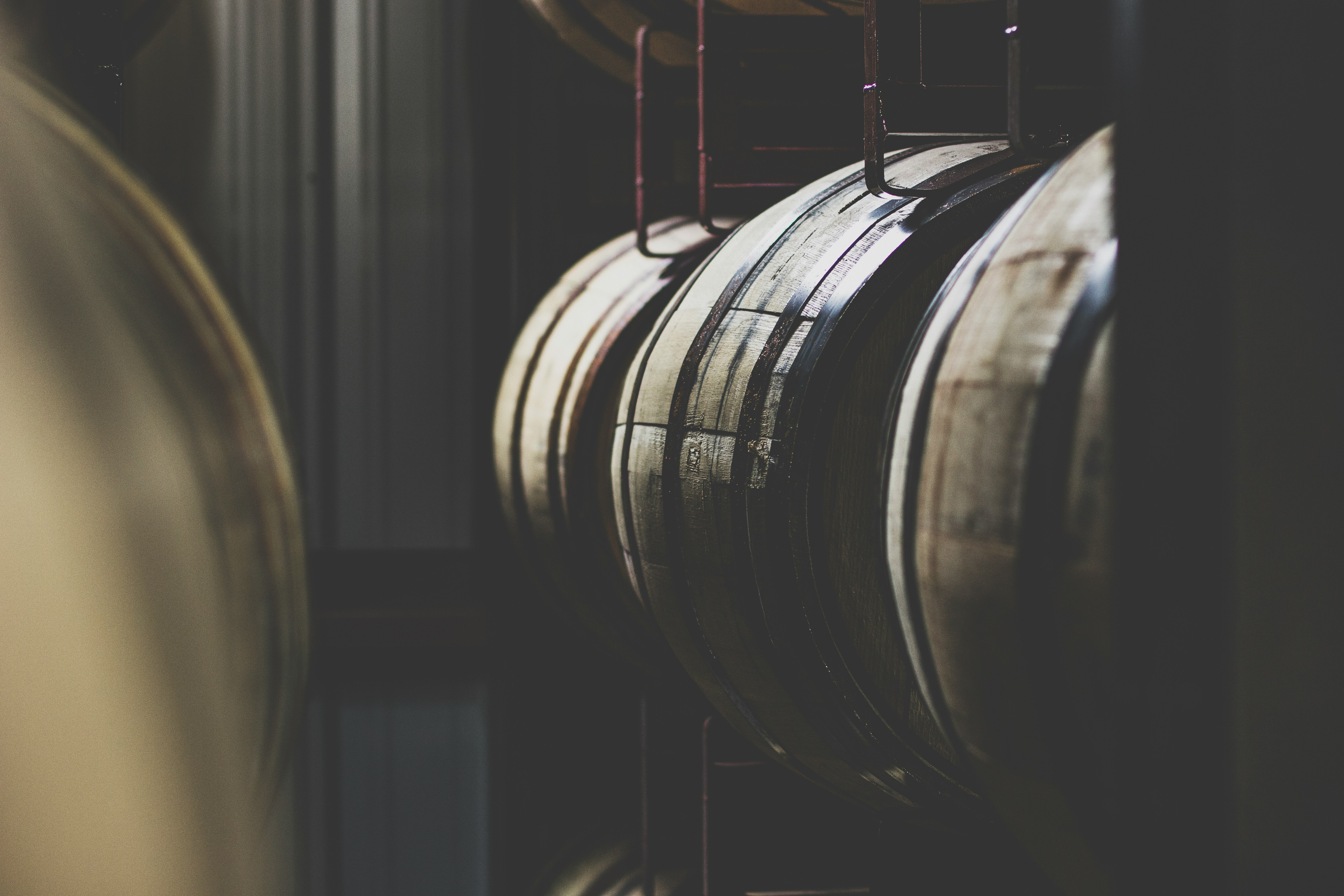 Bourbon barrels in atmospheric warehouse lighting