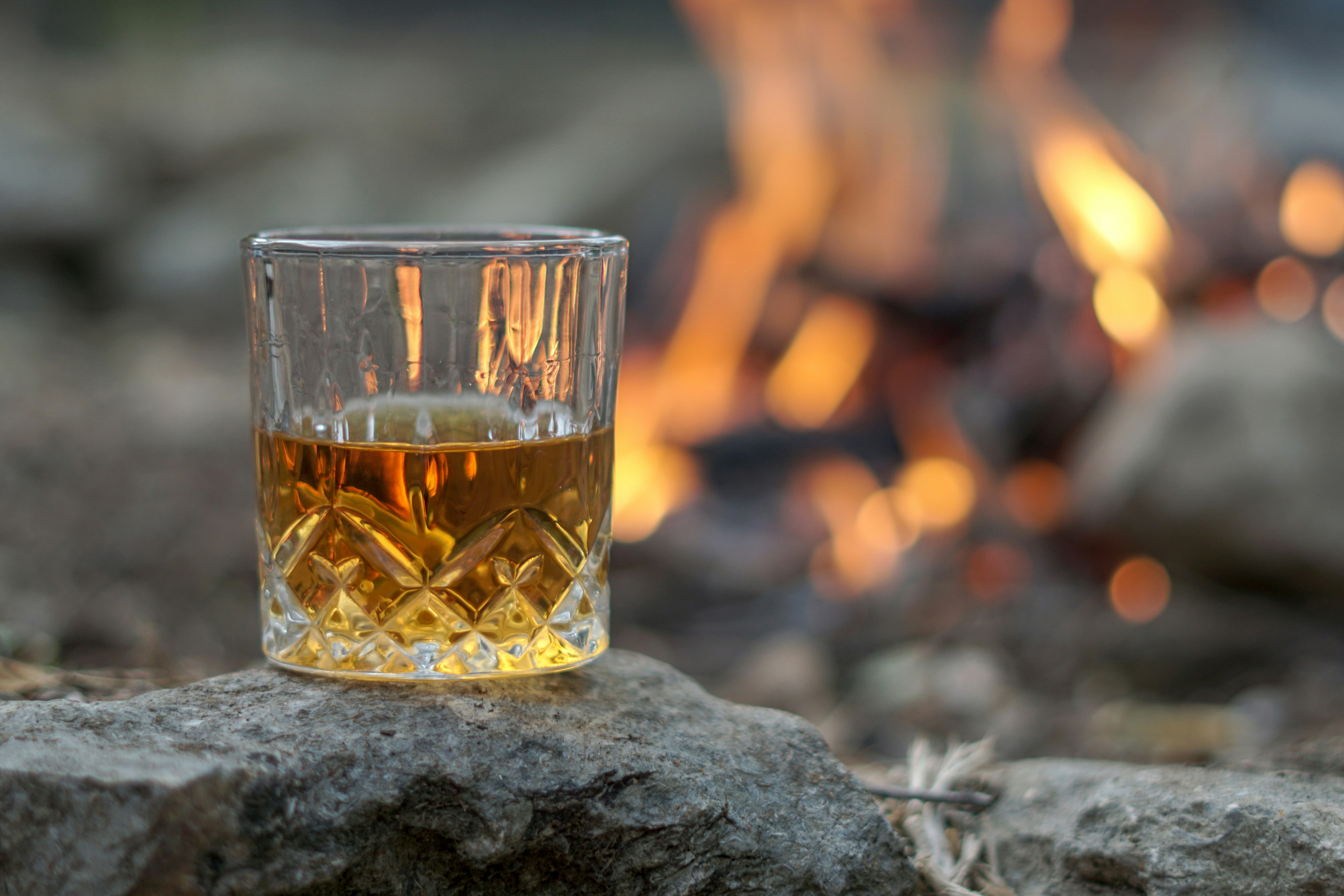 Bourbon glass beside a warm fire